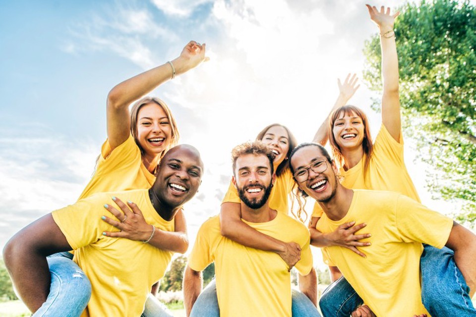 Diverse social work advocates celebrate at a park.