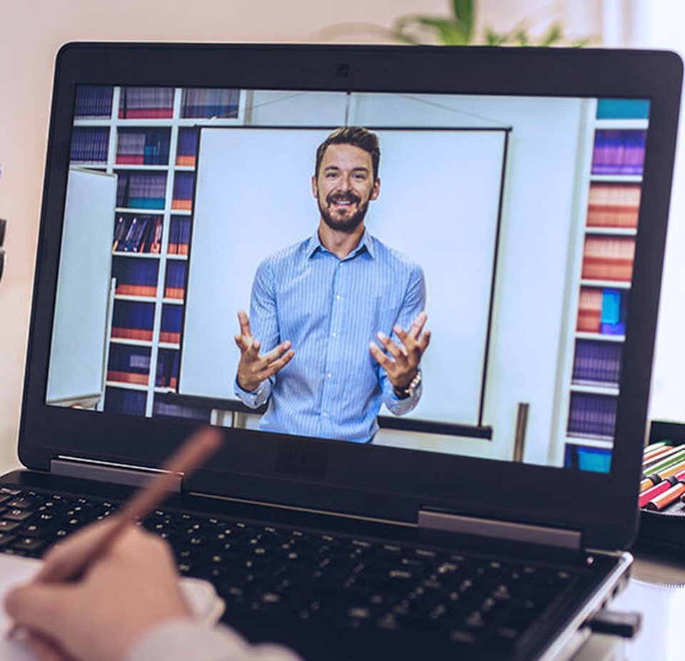 A student watches a virtual lecture on their laptop.