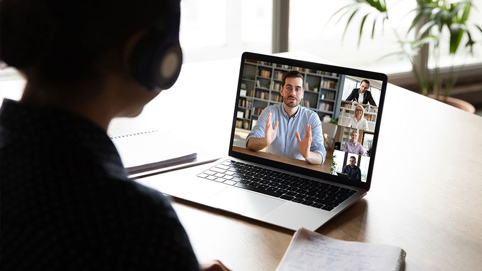 A male professor teaching via a online meeting.