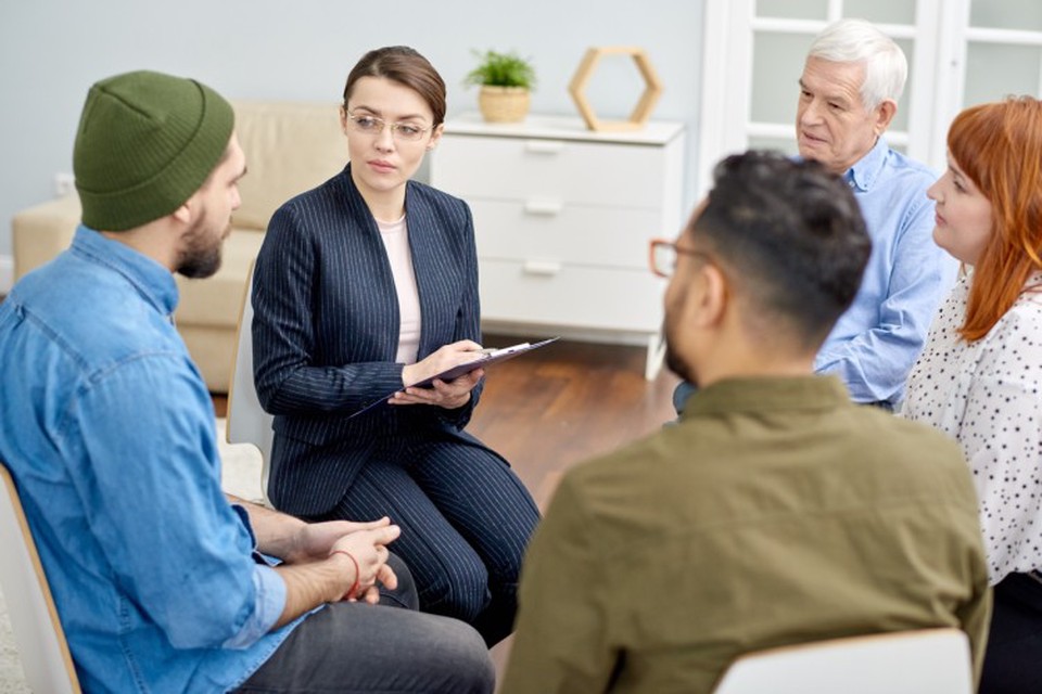 A clinical social worker leads a group therapy session.