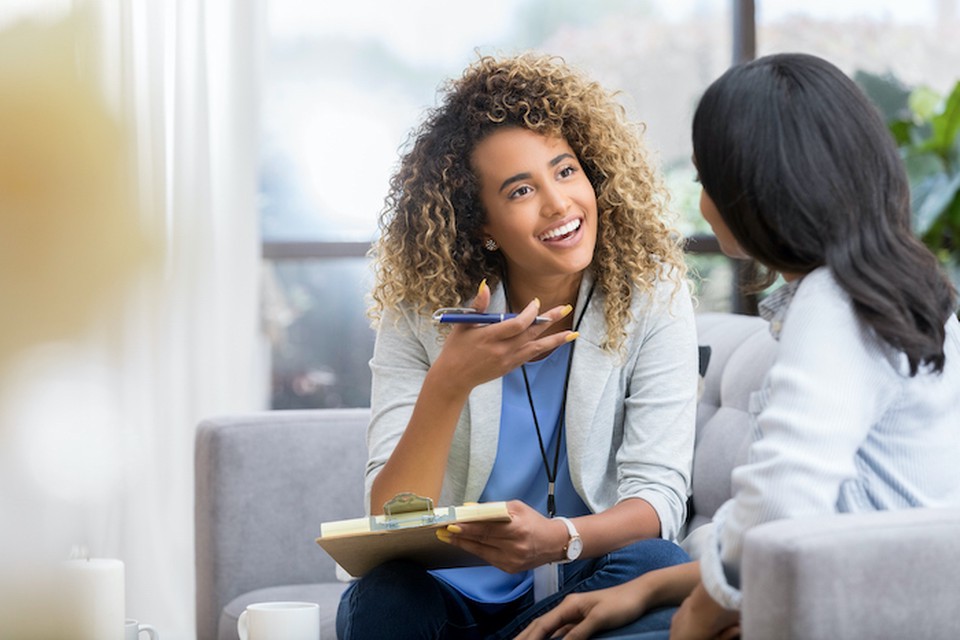 Two women talking on a couch