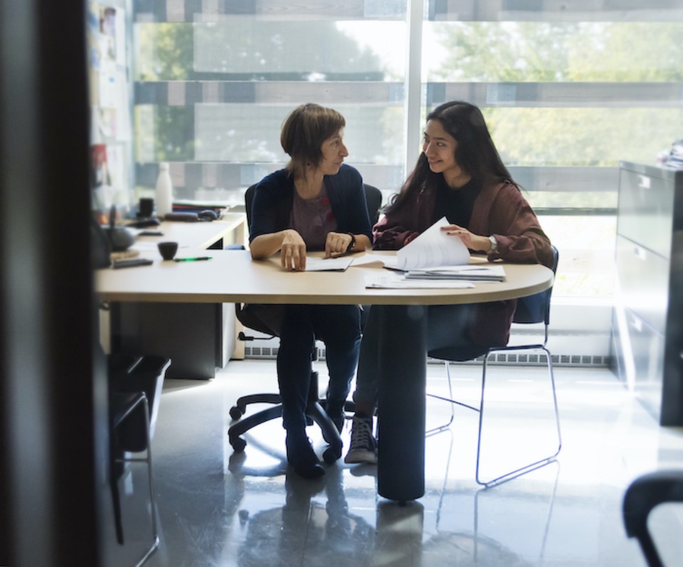 Two women sitting at a desk working on a project