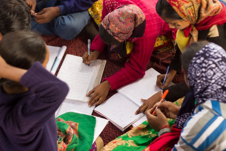 Schoolchildren write in notebooks in an Indian village.
