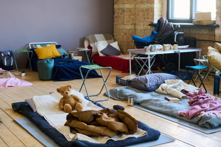 Bedding on the floor of a homeless shelter.