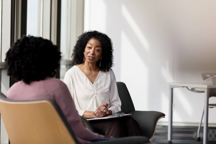 A social worker meets with a client in their office.