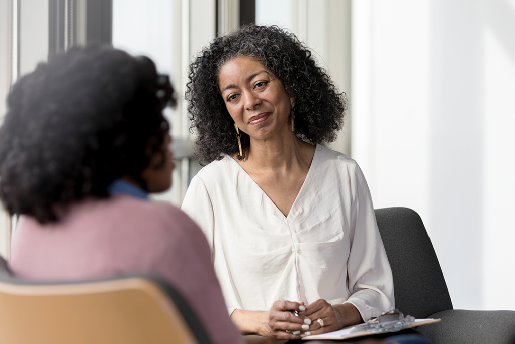 A social worker in an office confers with a client.