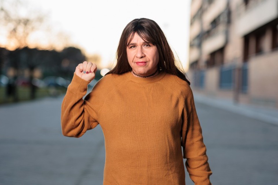 A person raises their hand to make the sign for domestic violence.